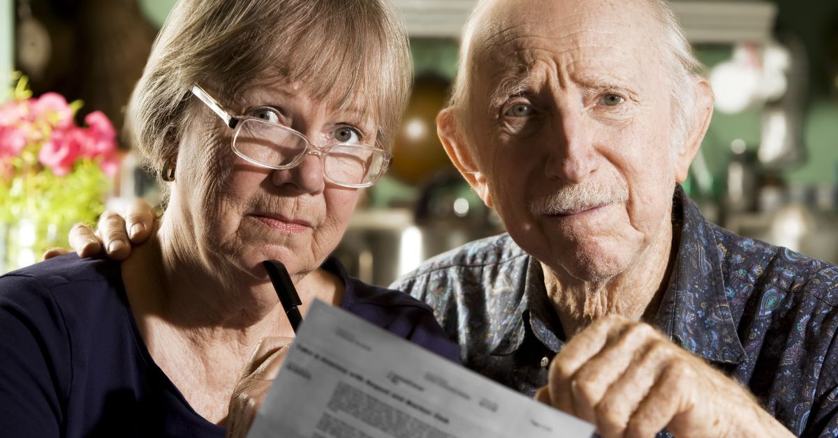 Image of an old couple holding a paper with retirement plans.
