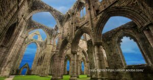 The towering arches of Tintern Abbey framing the blue sky