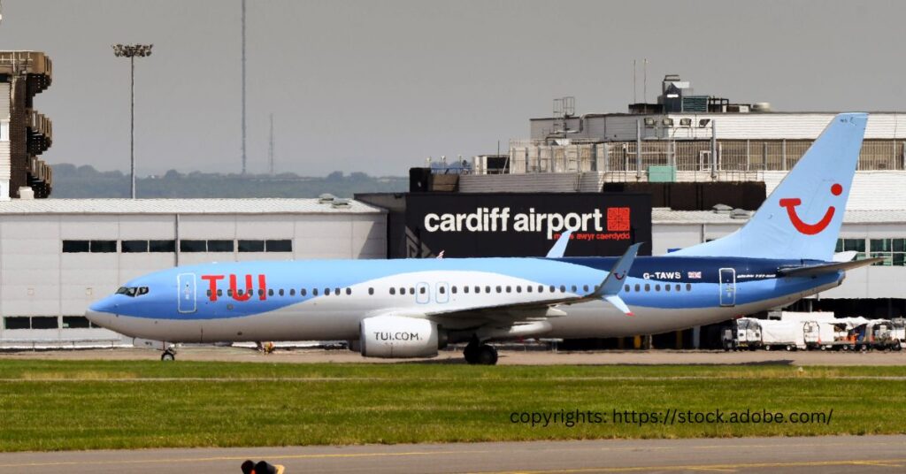 TUI Airways Boeing 737 aircraft at Cardiff Airport, with airport signage in the background.