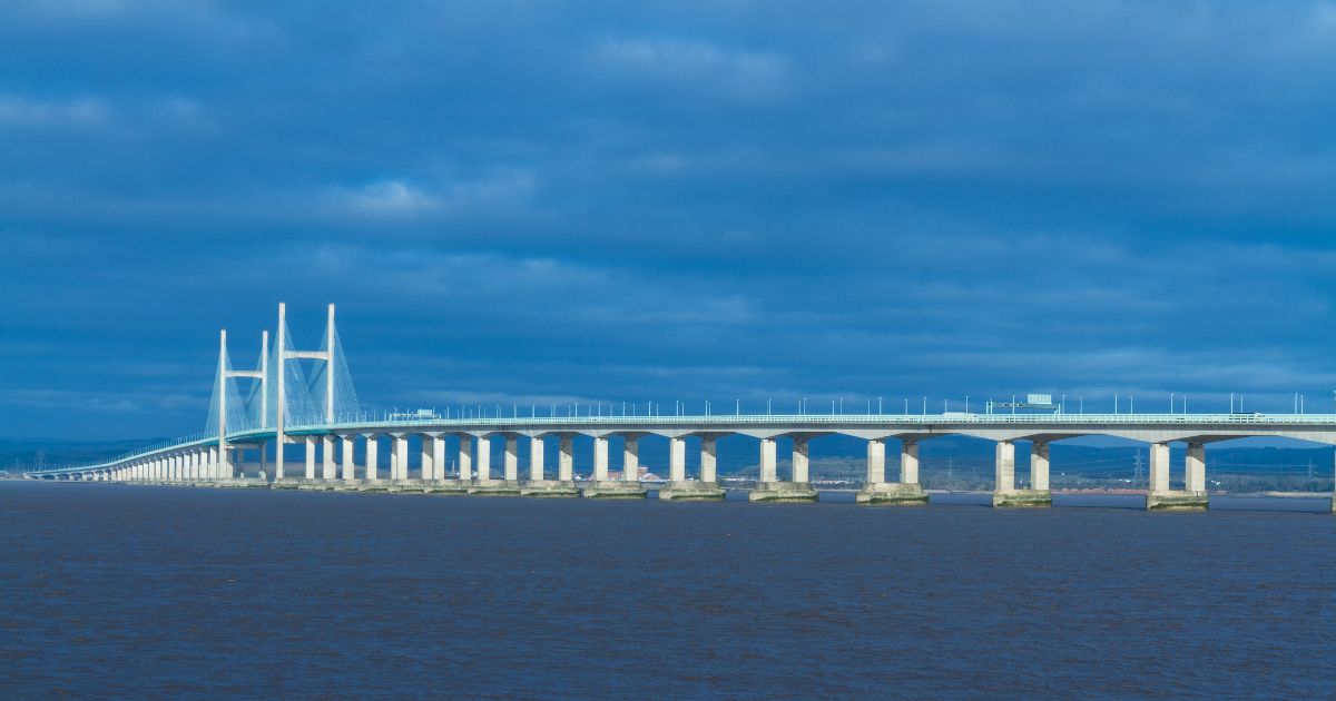 The expansive Prince of Wales Bridge, stretching across the River Severn under a blue sky, connecting Wales and England.