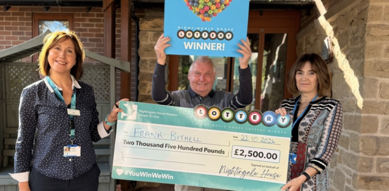 "Frank Bithell holding his £2,500 Nightingale House Hospice Lottery cheque with two Nightingale House staff members."