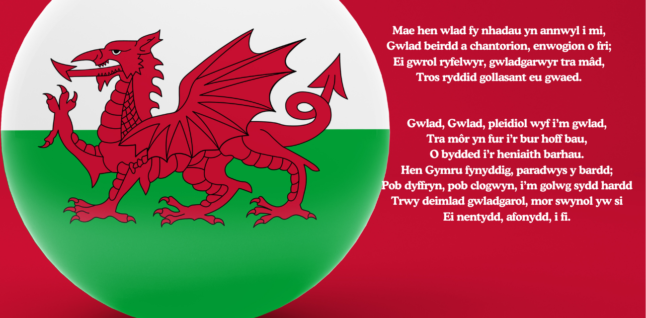 The Welsh flag featuring a red dragon on a white and green background, with the lyrics of the Welsh national anthem "Hen Wlad Fy Nhadau" written in white on the right side.