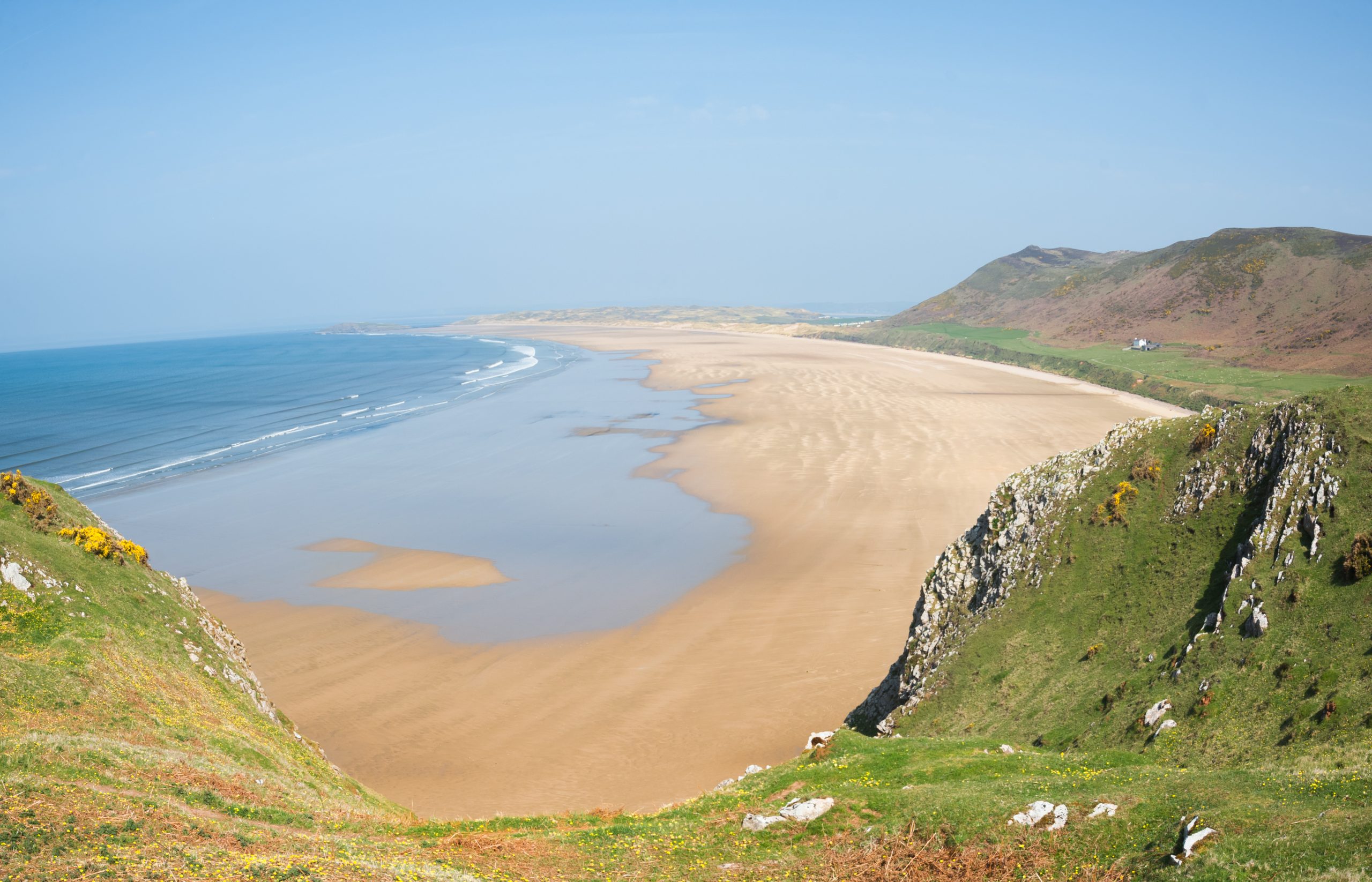 Elevated view of Rhossili Bay’s sweeping coastline seen from the cliffs above