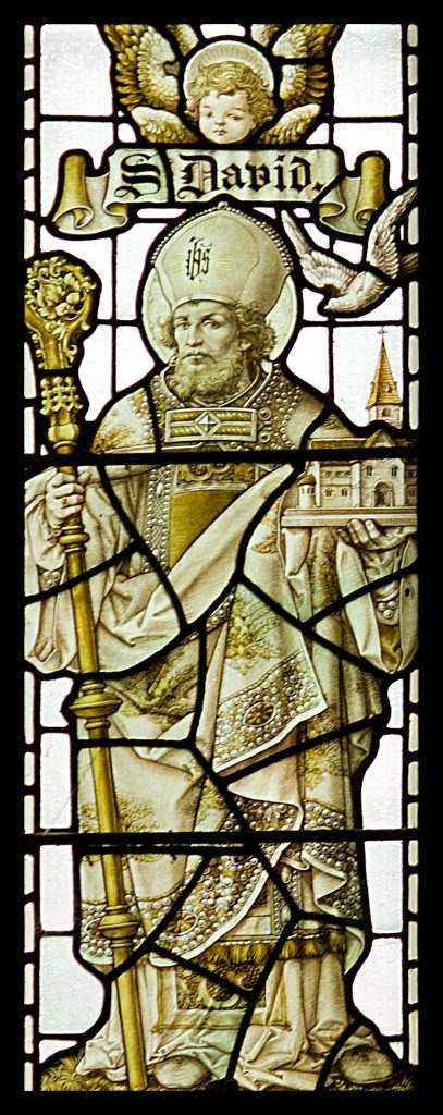 Stained glass depiction of St David holding a bishop’s staff and monastery