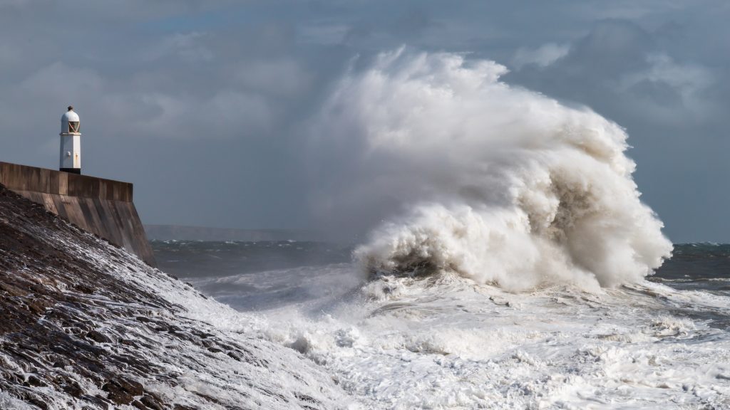 Giant storm waves crash over the sea wall and lighthouse at Porthcawl, South Wales, under heavy Atlantic conditions.